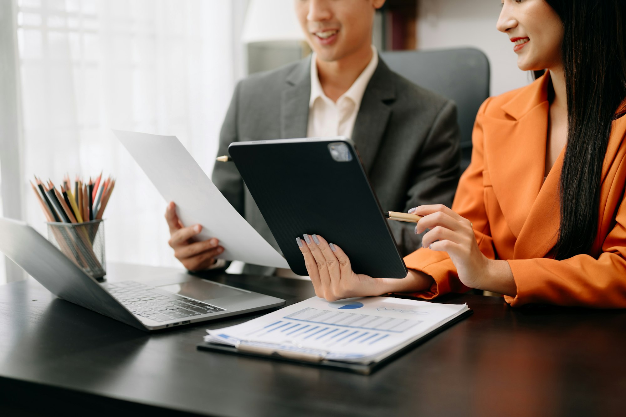 Businesswoman and team analyzing financial statement Finance task. with smart phone and laptop